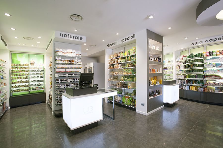 Interno moderno della farmacia con cosmetici, con banconi bianchi, scaffali di prodotti e un’illuminazione intensa