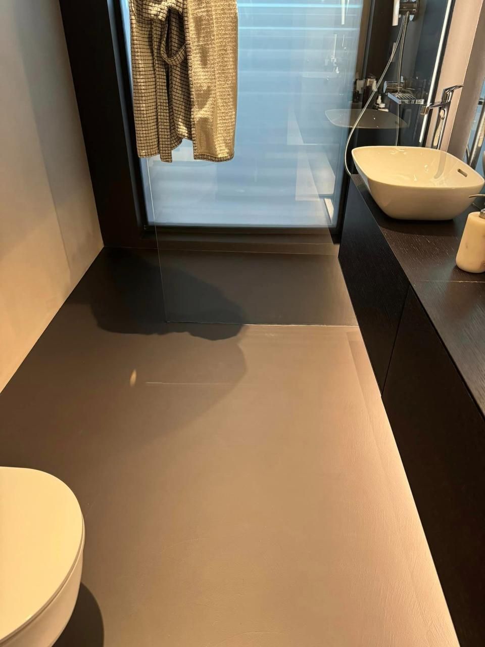 Une salle de bain avec WC, lavabo et douche.