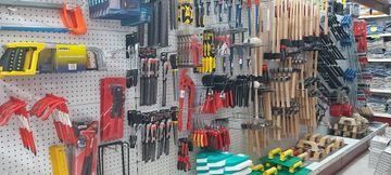 Un montón de herramientas están colgadas en la pared de una tienda.