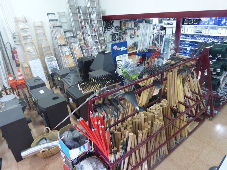 Pasillo interior de la tienda con escaleras, herramientas y estantes de suministros de ferretería.