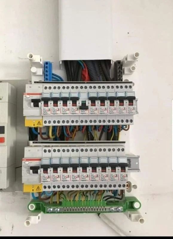 Boîte à fusibles électriques avec rangées de disjoncteurs et câblage.