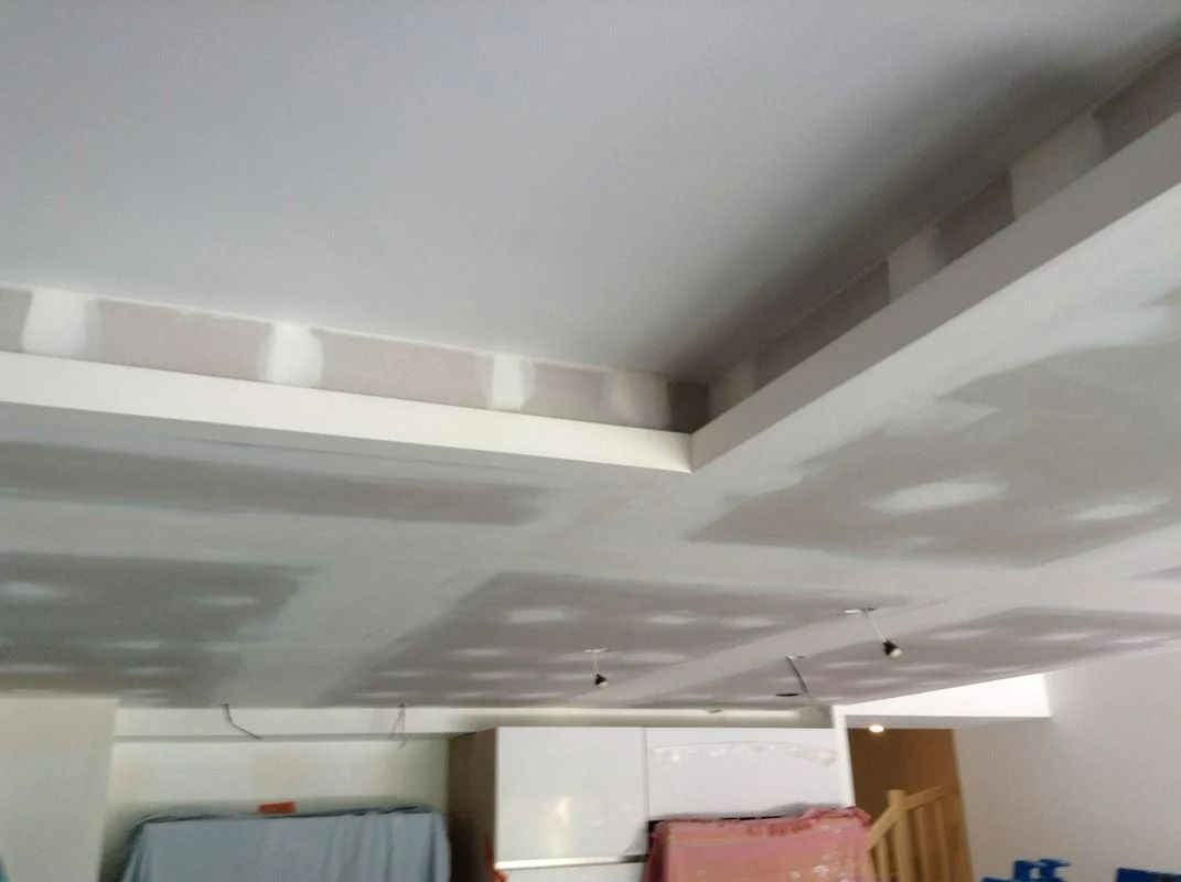 Plafond en construction : plaques de plâtre installées, prêtes pour les finitions.