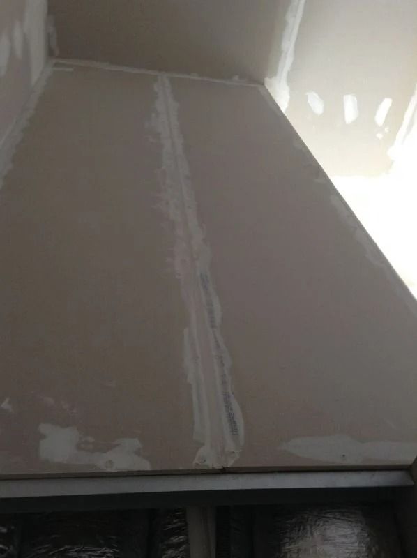 Plafond en plaques de plâtre avec enduit de joint apparent et non peint.