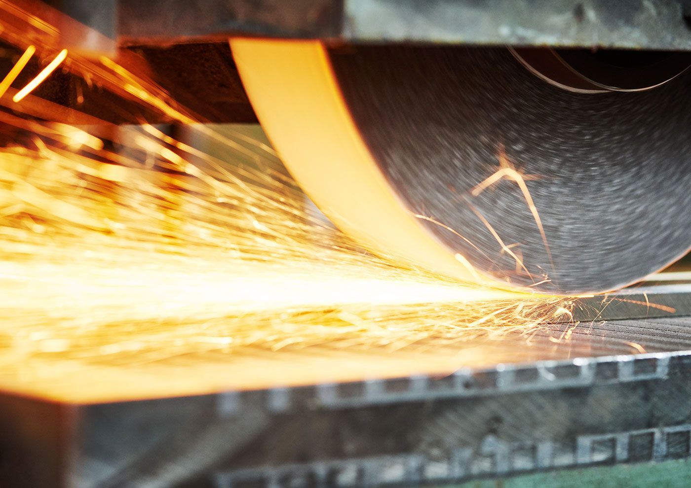 Borchert & Fuhrmann GmbH - Eine Maschine schleift ein Stück Metall, wobei Funken austreten.