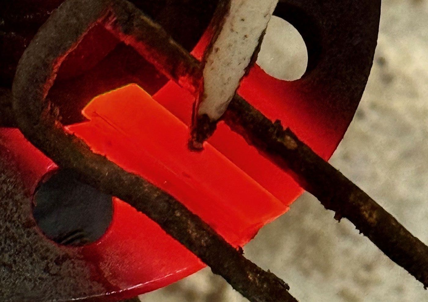 Borchert & Fuhrmann GmbH - Eine Person schweißt ein Stück Metall vor blauem Hintergrund