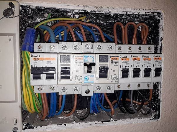 Cuadro eléctrico con diversos disyuntores y cableado.