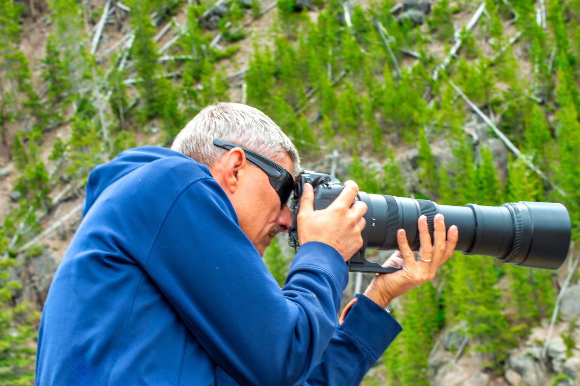A man with a camera enjoying Yellowstone Tours For Seniors​.