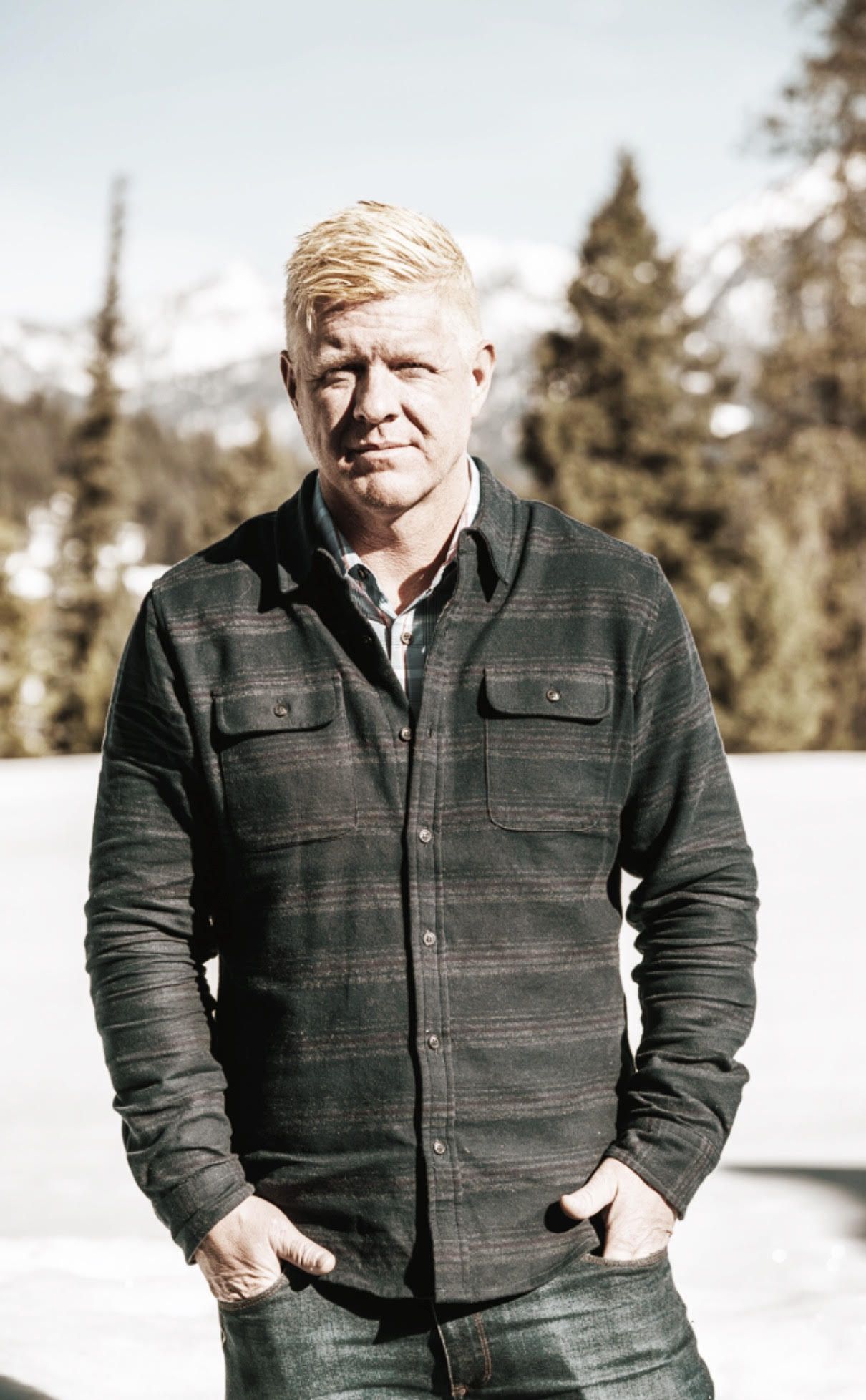 A black and white photo of a man and woman standing next to a wooden fence.