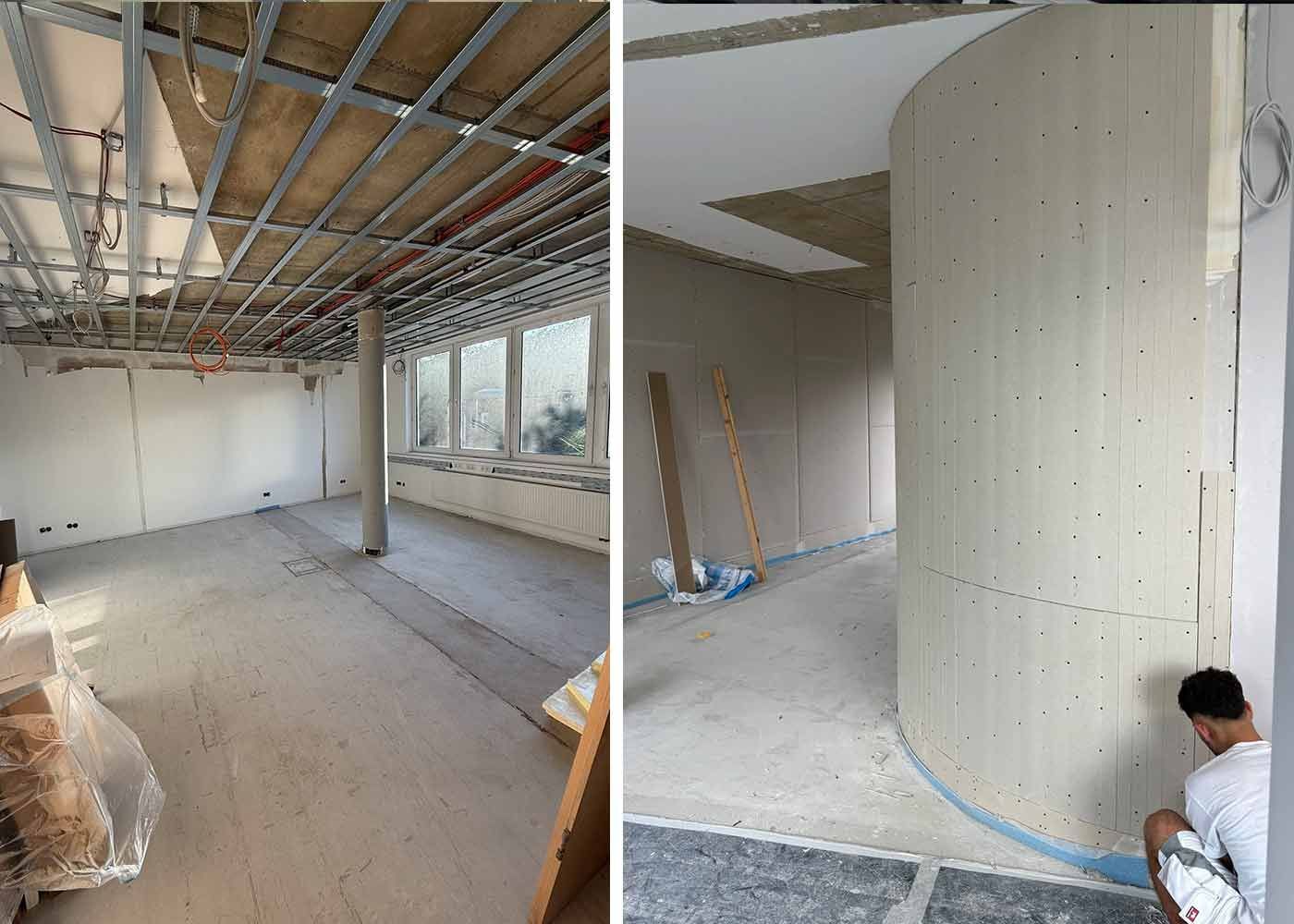 Innenbaustelle mit freiliegender Decke, Betonsäule und Arbeitern in der Nähe einer großen Wandkurve