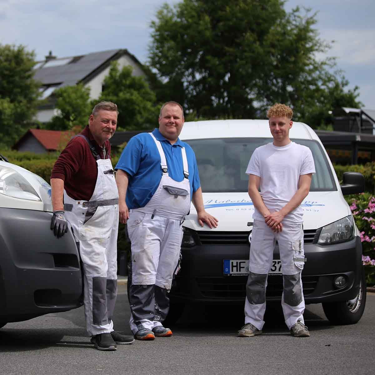 Drei Männer stehen vor einem Lieferwagen mit der Aufschrift