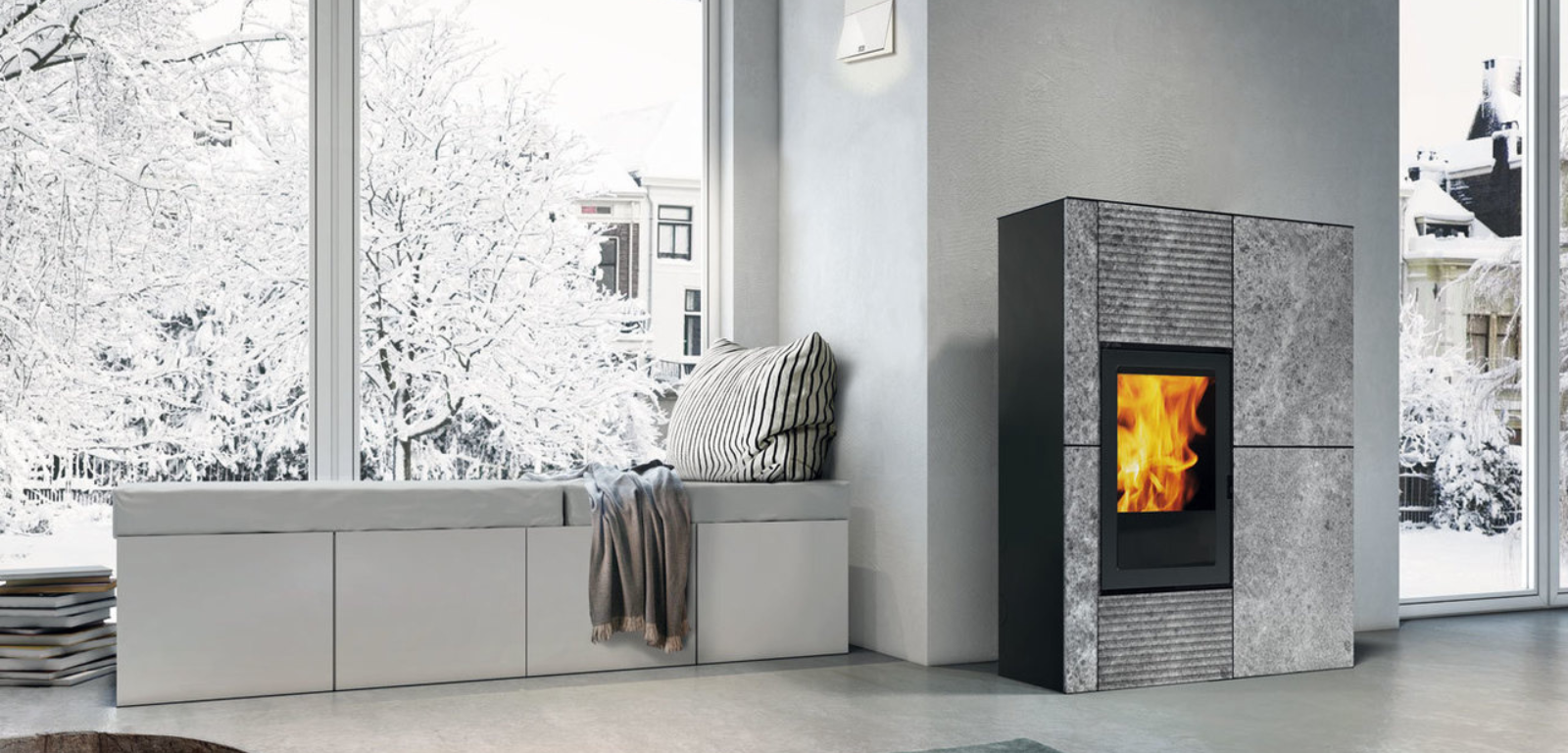 Un poêle à granulés est placé dans une pièce à côté d'un mur avec un papier peint à motifs.