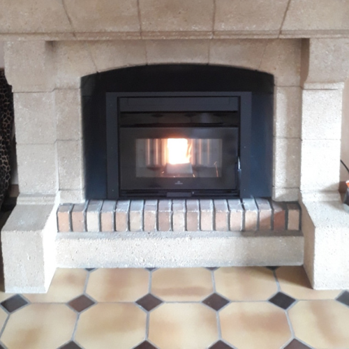 Une cheminée avec un poêle et un sol carrelé