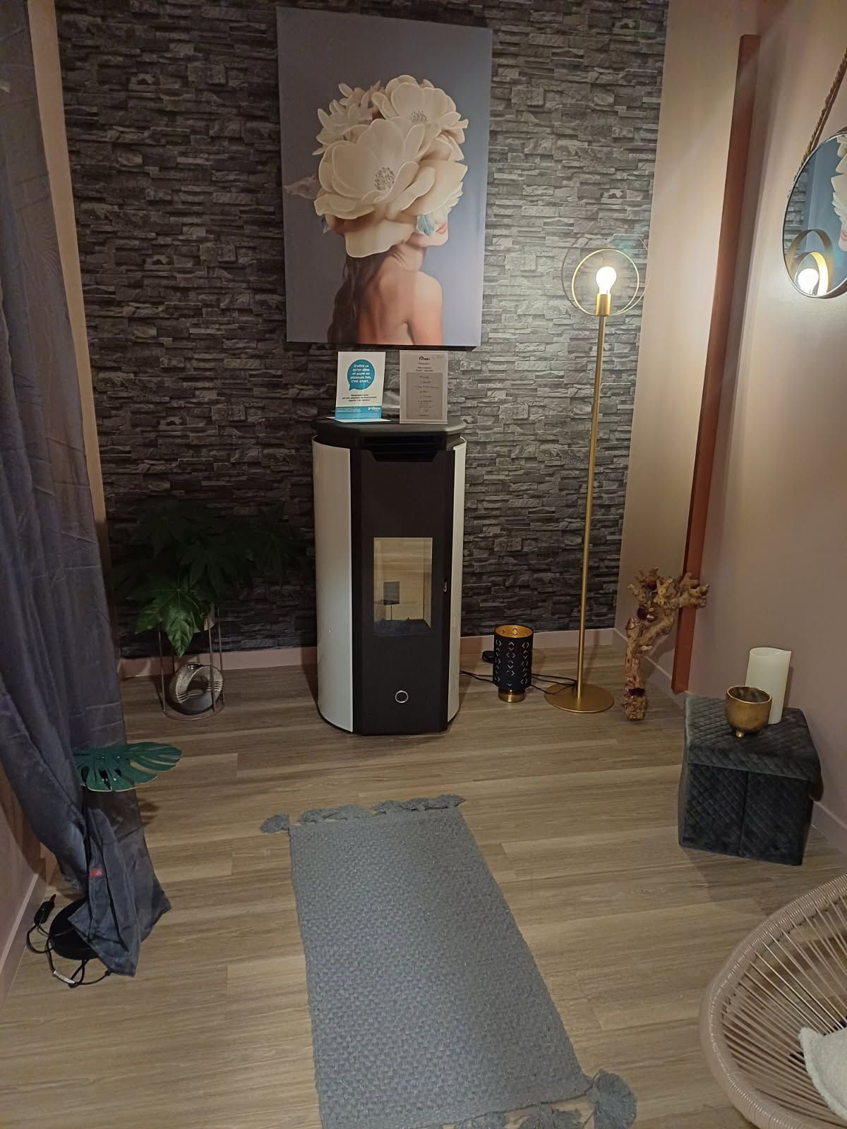 Une pièce avec un poêle et un tableau au mur.