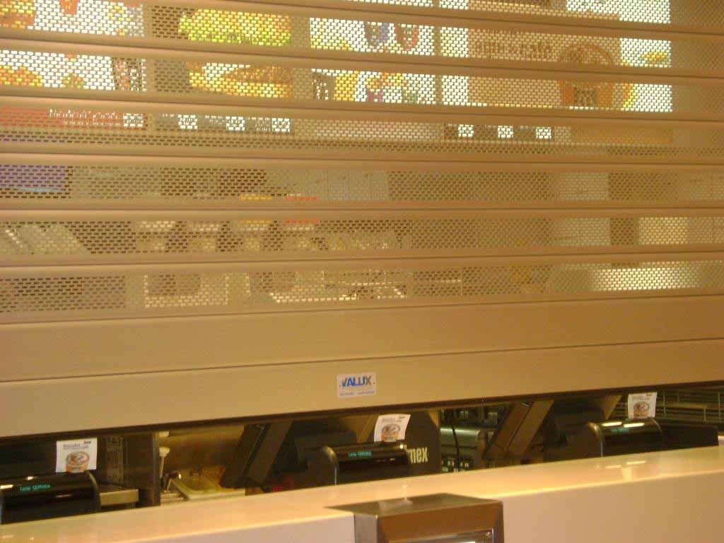 Persiana de seguridad de metal perforada cerrada sobre el mostrador de un restaurante.