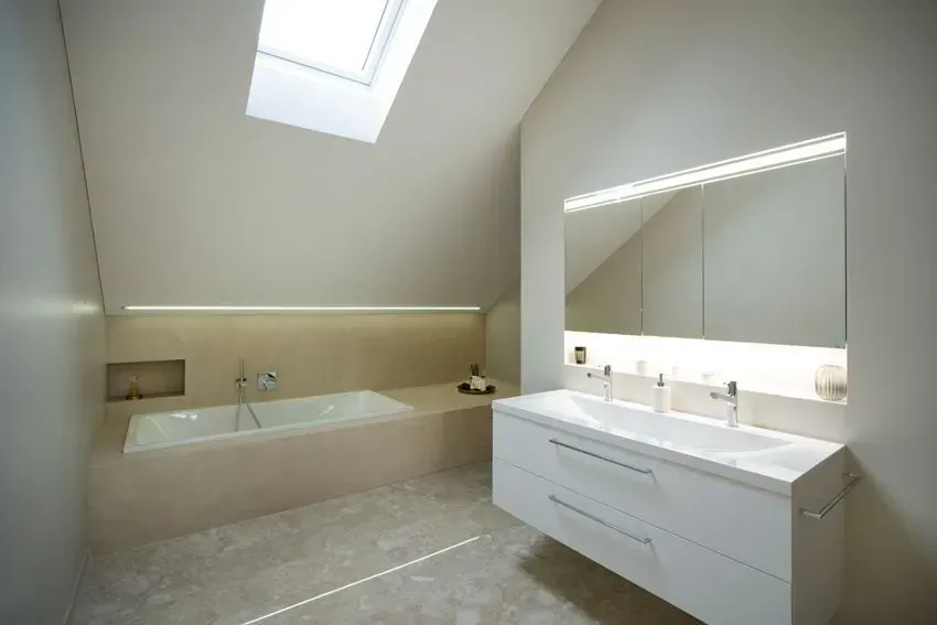 Modernes Badezimmer mit Oberlicht, freistehender Badewanne, großem Spiegel und Doppelwaschtisch.