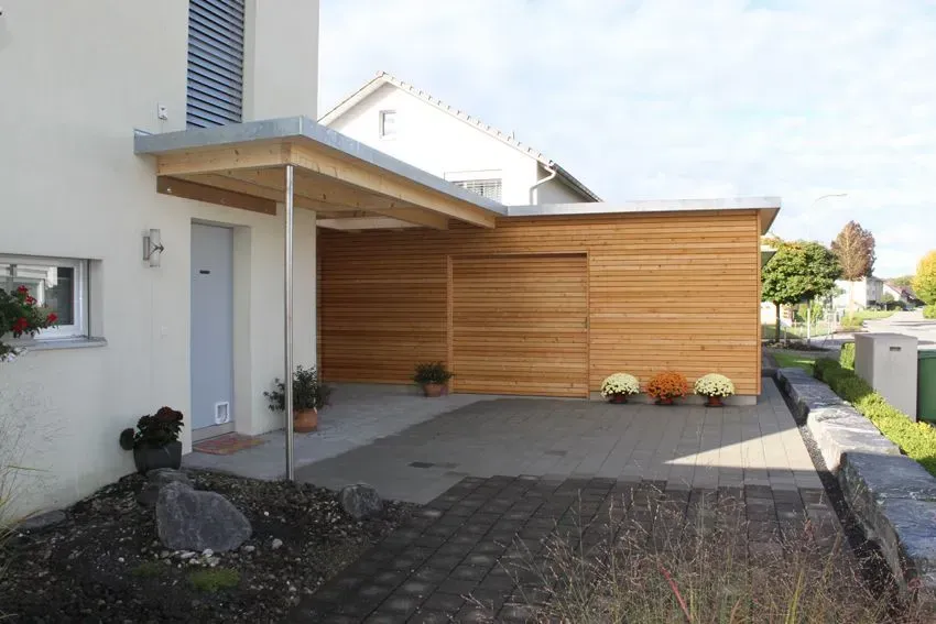 Moderner Eingangsbereich mit Terrasse aus Holz, gepflastertem Innenhof und Kiesgarten