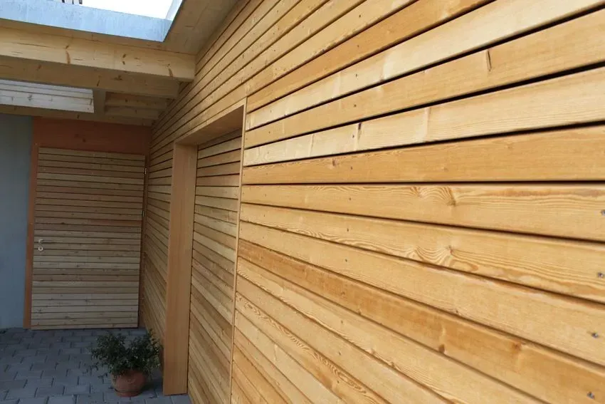 Ein holzgetäfelter Flur mit Oberlicht und einer Topfpflanze am Ende