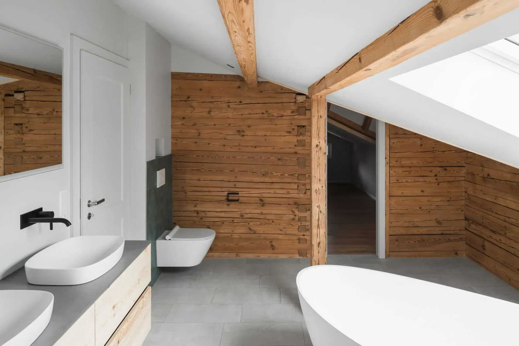 Modernes Badezimmer im Landhausstil mit holzgetäfelten Wänden, weißen Armaturen und Dachfenstern