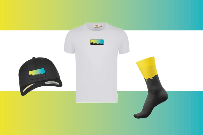 Weißes T-Shirt, schwarze Kappe und schwarz-gelbe Socken auf weißem Hintergrund mit gelb-türkisfarbenem Farbverlauf am Rand
