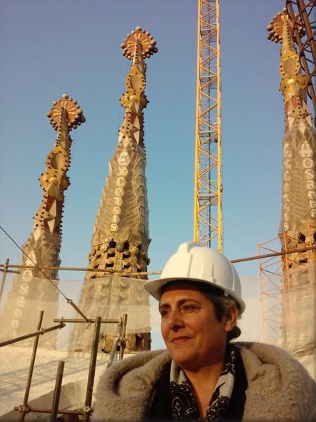 Dos mujeres toman fotografías de un paisaje urbano desde un punto elevado bajo un cielo azul.