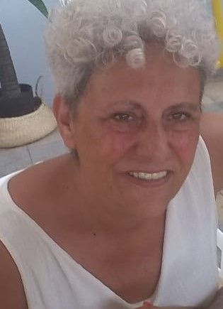 Dos mujeres toman fotografías de un paisaje urbano desde un punto elevado bajo un cielo azul.