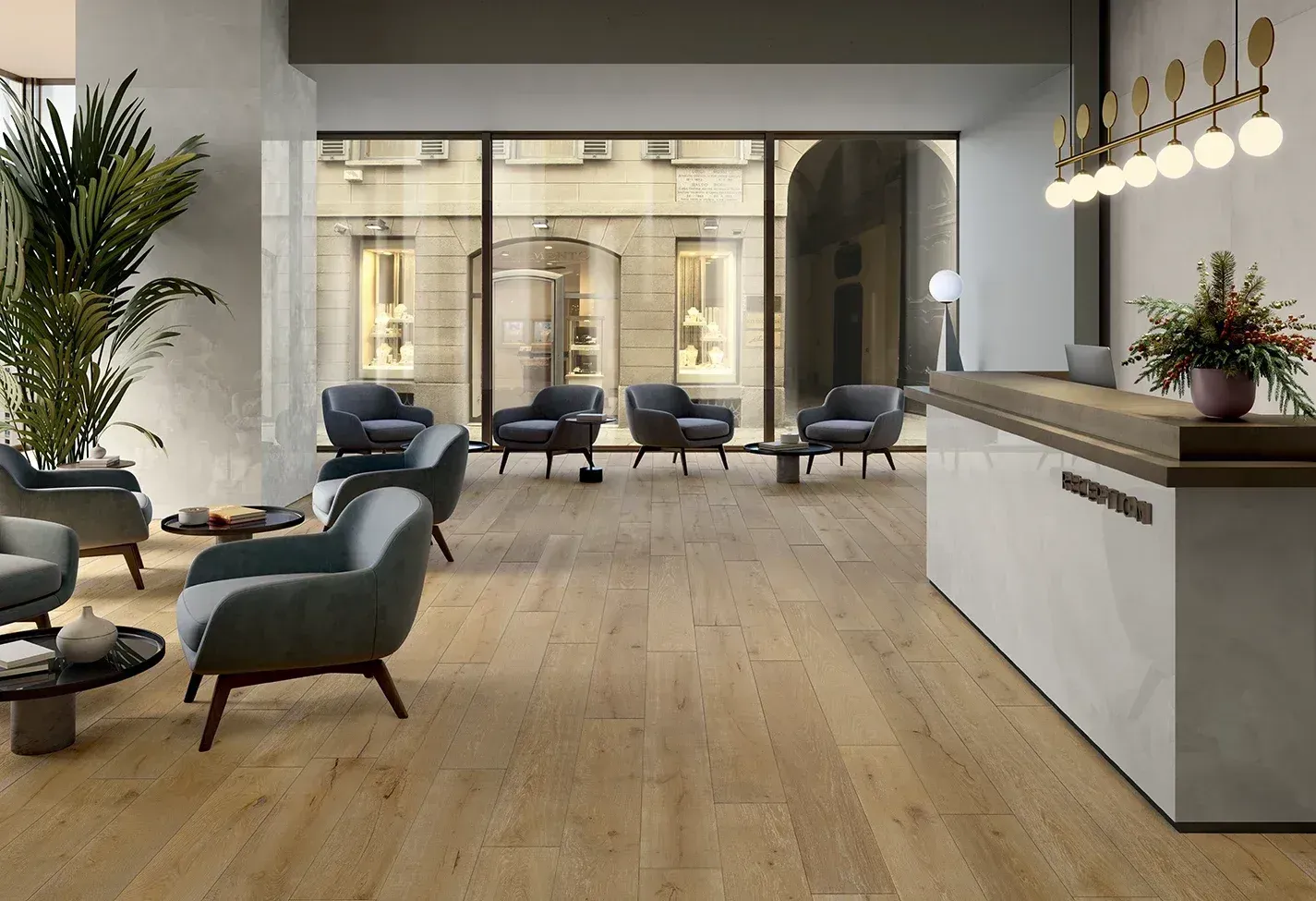 Hall d'hôtel moderne avec chaises turquoise, parquet, paroi vitrée et comptoir de réception