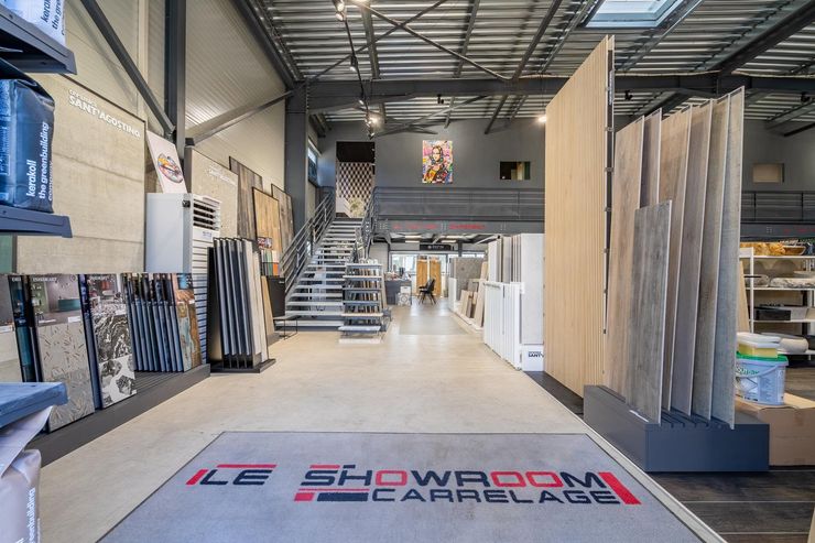Intérieur d'une salle d'exposition d'entrepôt avec présentoirs, escaliers et tapis de sol de marque