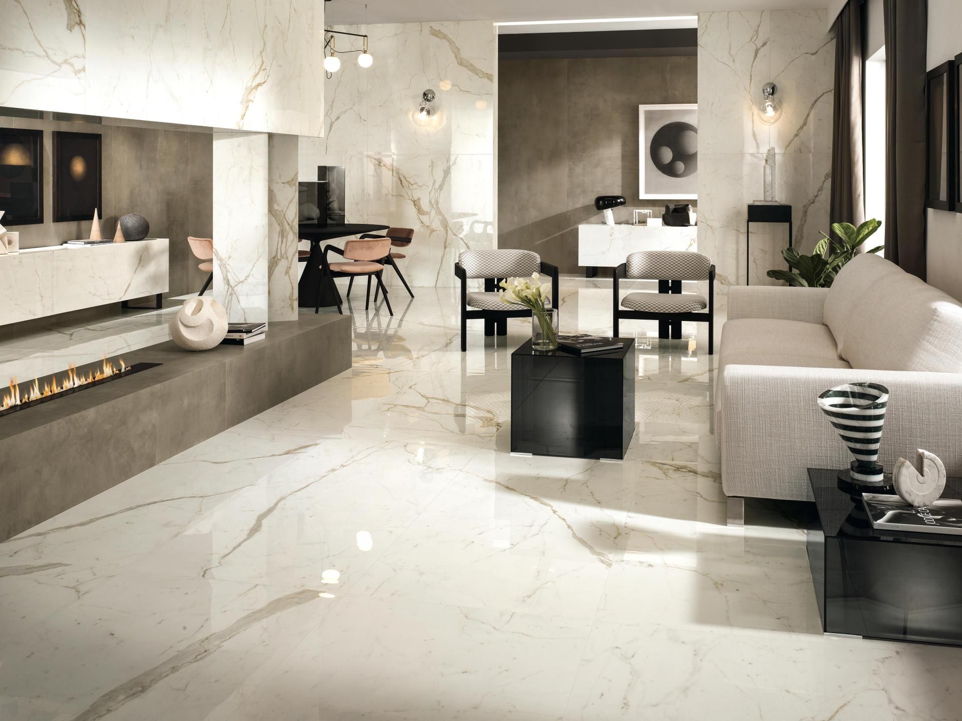 Salon moderne avec sol en marbre blanc, canapé beige, cheminée, table à manger et meubles d'appoint noirs.