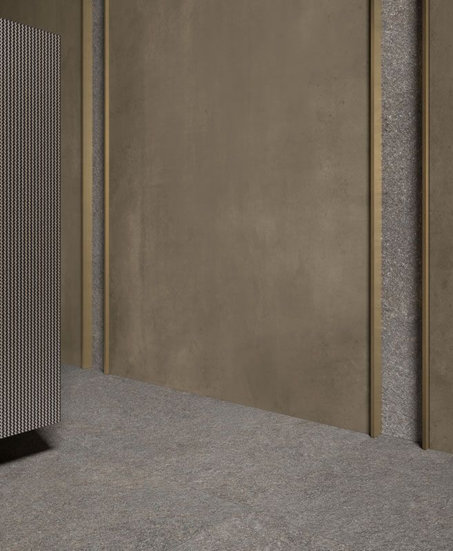 Couloir moderne vide avec murs beiges, moquette grise et panneau texturé sur la gauche