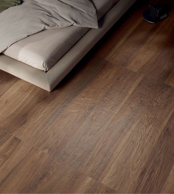 Salon moderne avec un large parquet, deux canapés et une table basse près de grandes fenêtres.