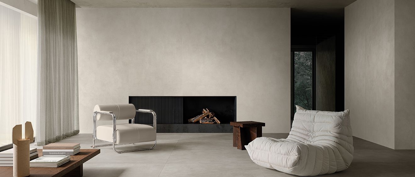 Salon minimaliste moderne avec cheminée, fauteuil blanc et tons neutres doux