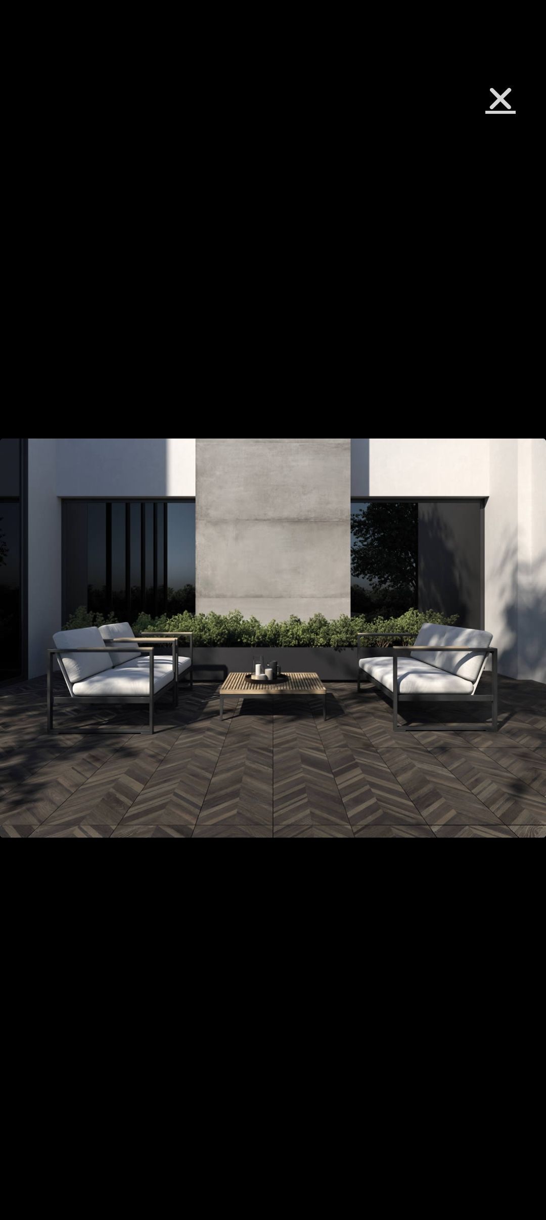 Terrasse extérieure moderne avec piscine, marches en pierre blanche et mobilier minimaliste offrant une vue sur la mer.
