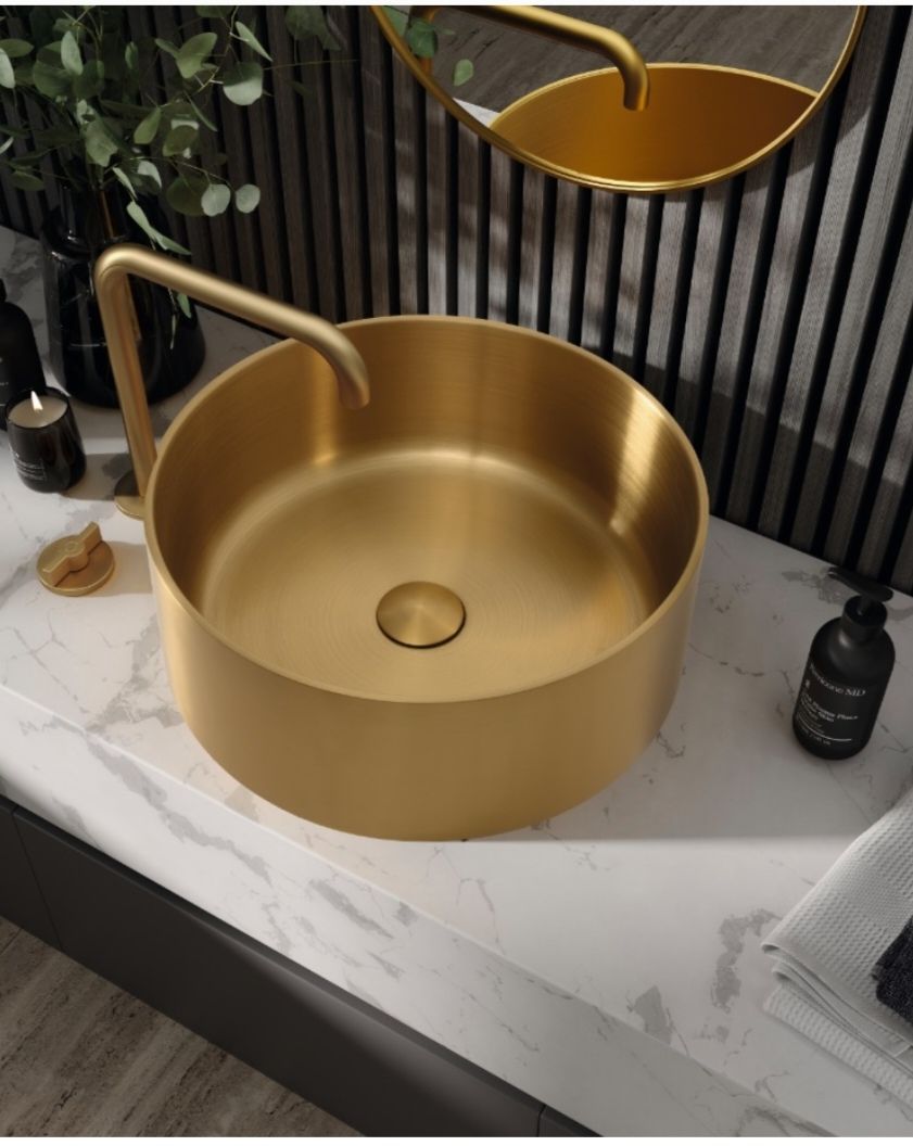 Meuble-lavabo moderne avec miroir ovale, vasque en pierre, suspension lumineuse et mur carrelé aux tons neutres.