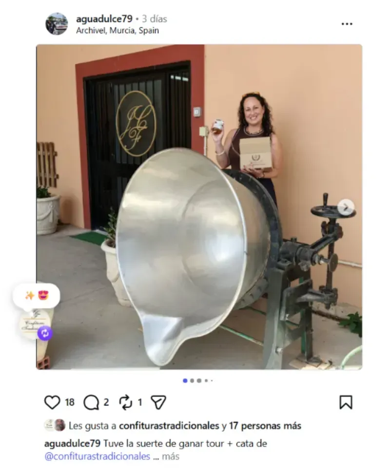 Mujer sosteniendo un certificado junto a una cuchara de plata gigante de utilería en una entrada al aire libre.