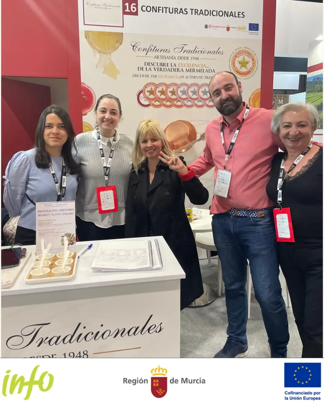 Cinco personas posan en un stand comercial con la marca “Tradicionales info” y distintivos rojos.