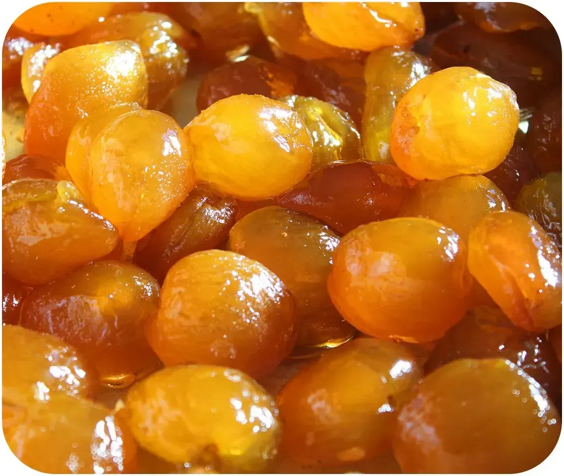 Primer plano de trozos de fruta seca de color naranja brillante, probablemente pasas, apilados.