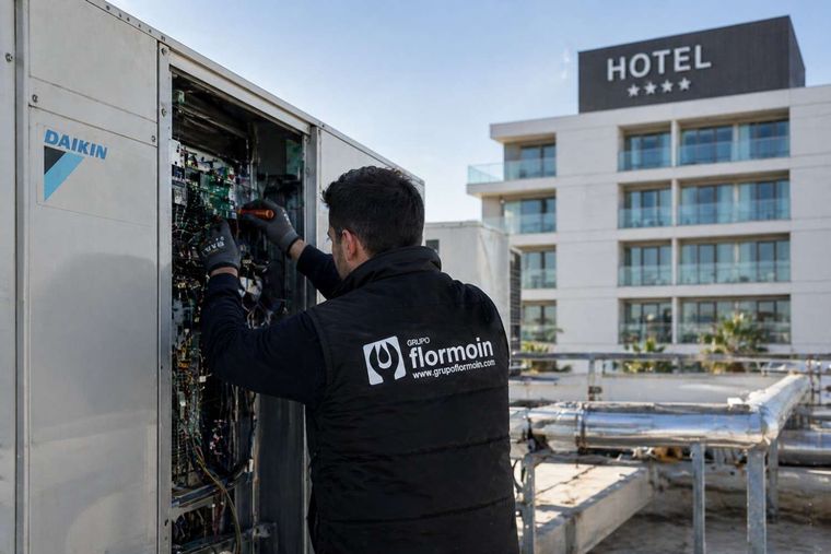 Un técnico trabaja en las unidades de climatización instaladas en la azotea de un edificio hotelero.
