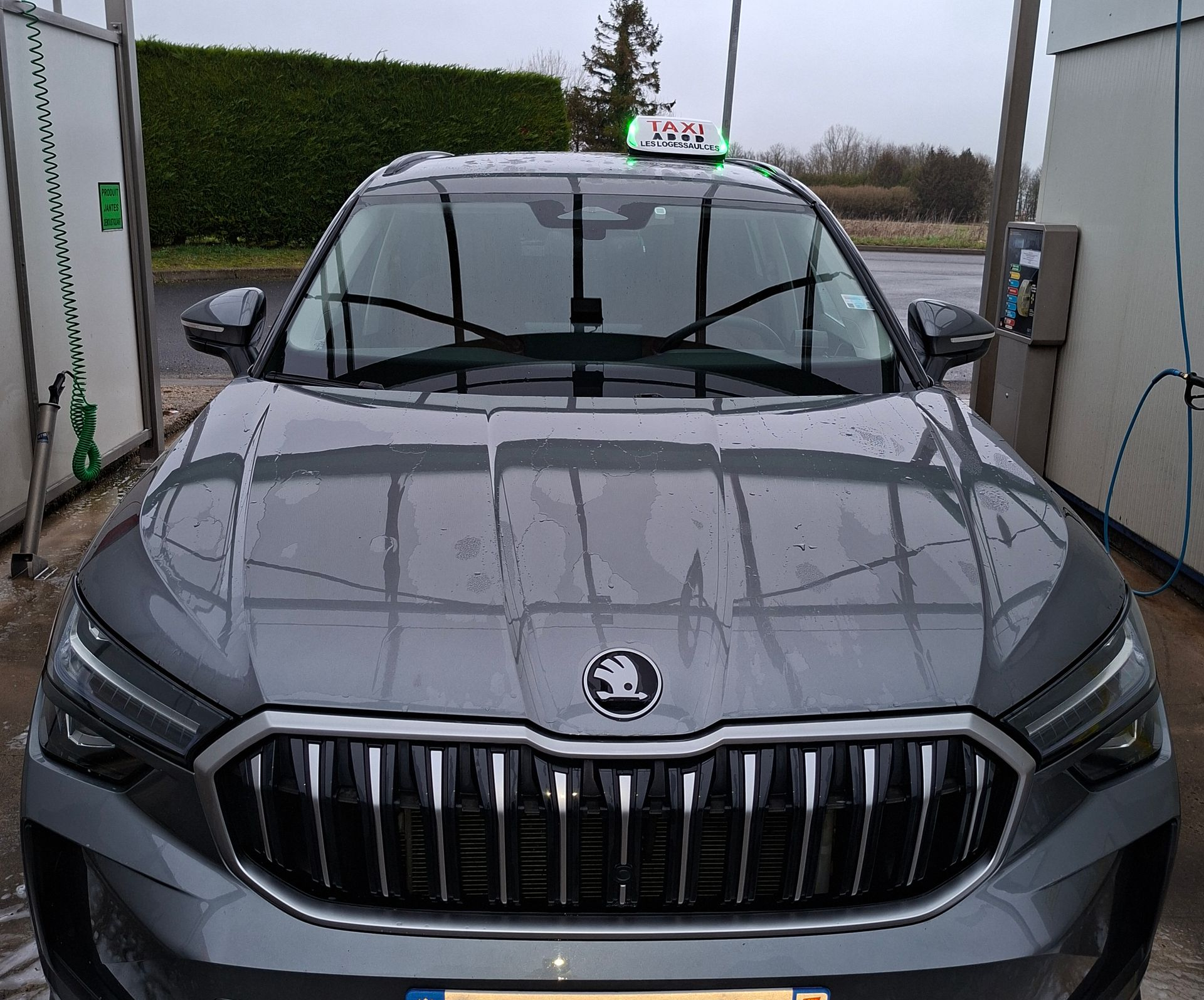 Taxi Skoda gris dans une station de lavage. Vue de face.