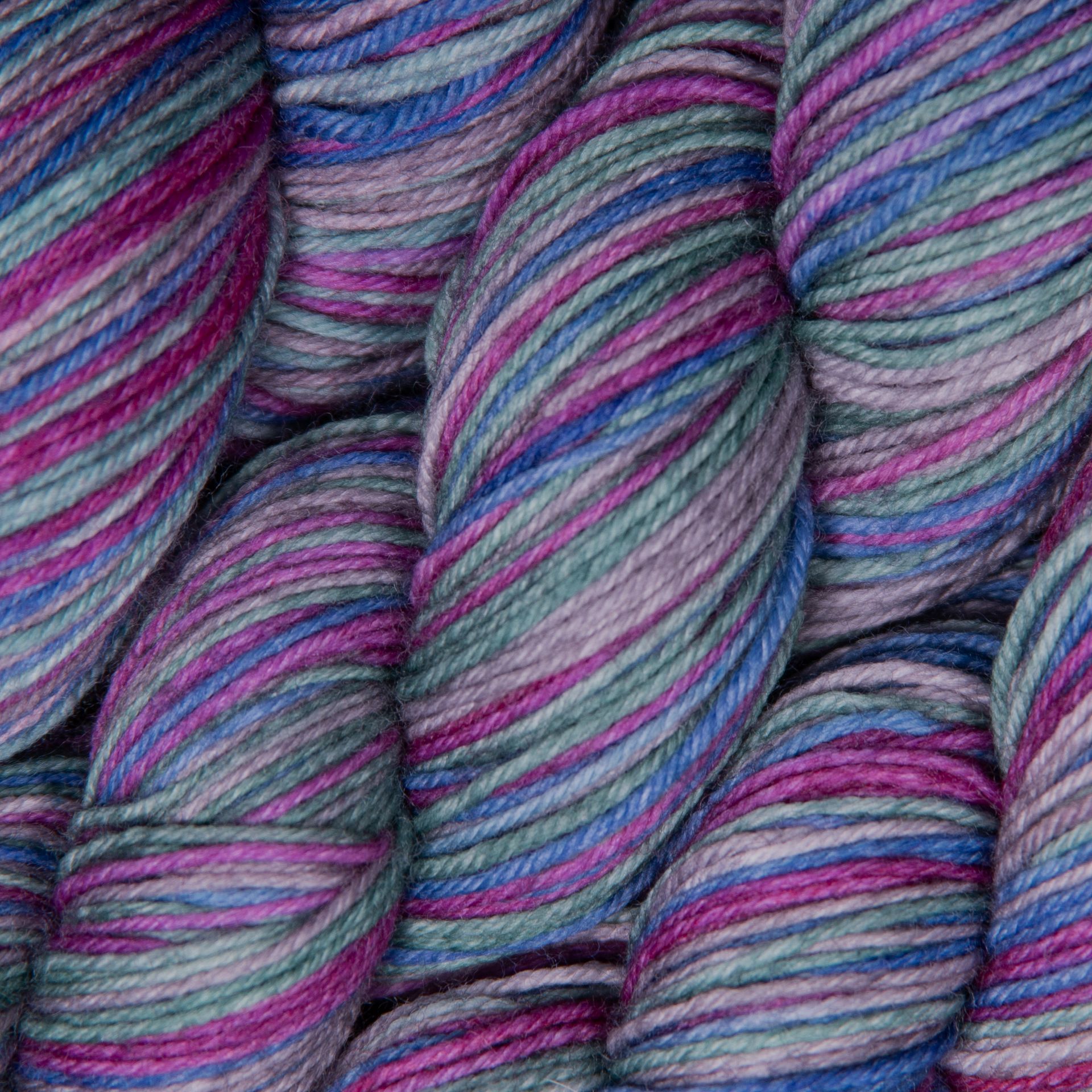 Knäuel buntes Garn in Blau-, Lila- und Grüntönen.