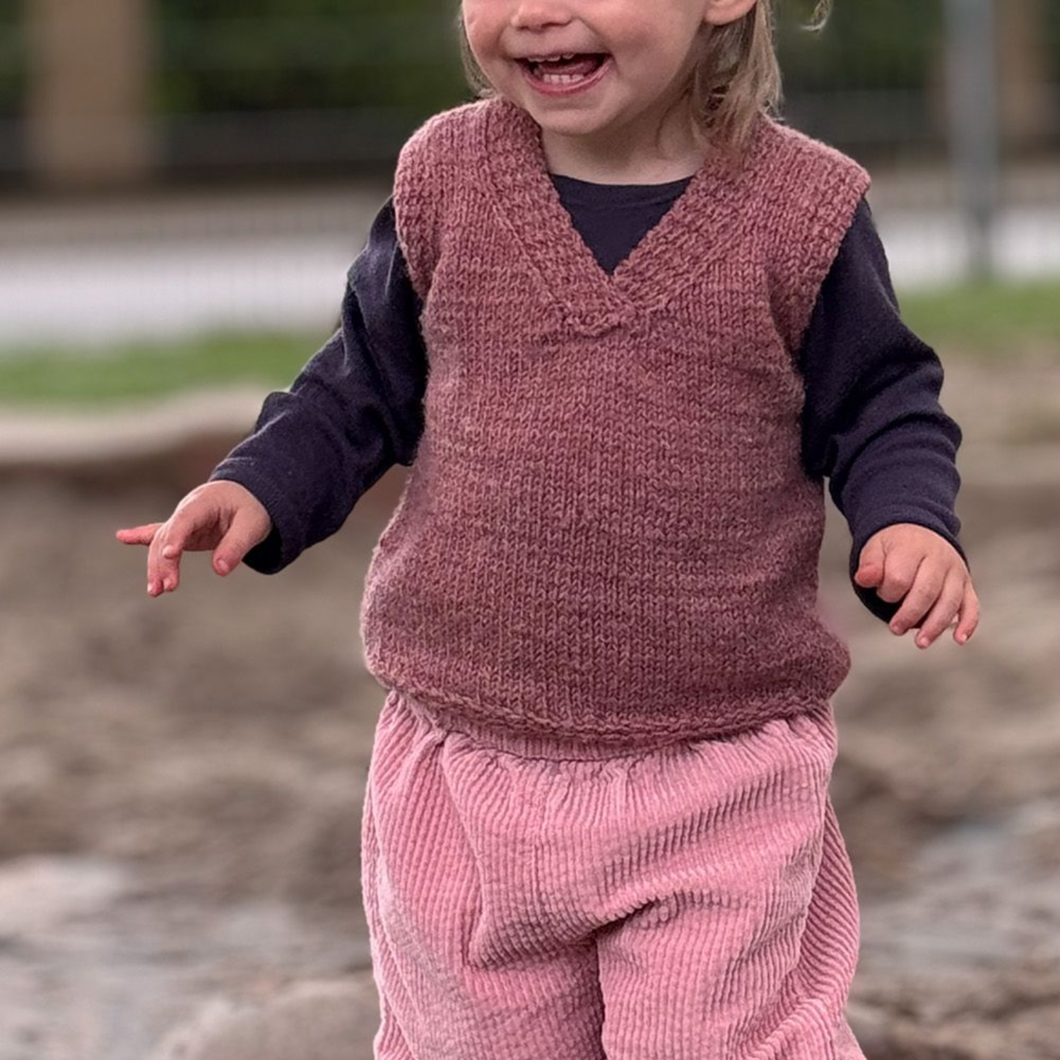 Ein Paar blaue Spitzenstricksocken auf einer Grasfläche.