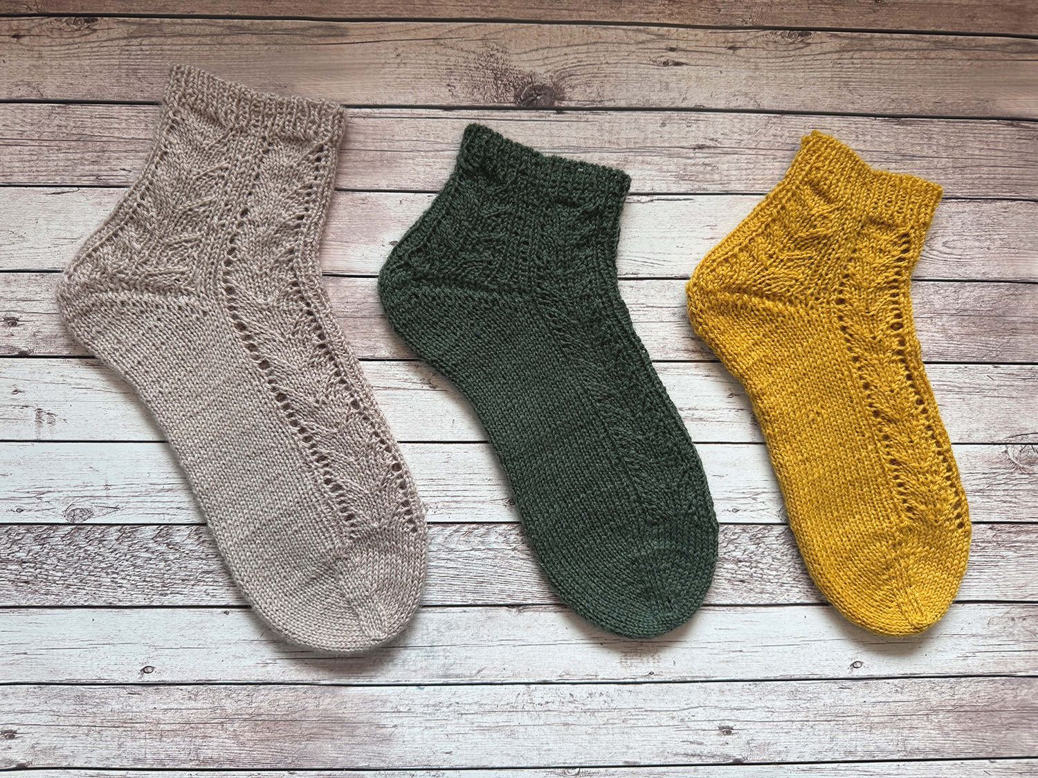 Nahaufnahme einer teilweise fertiggestellten blau-türkis gestrickten Socke, die die Ferse und die Strukturmuster zeigt.