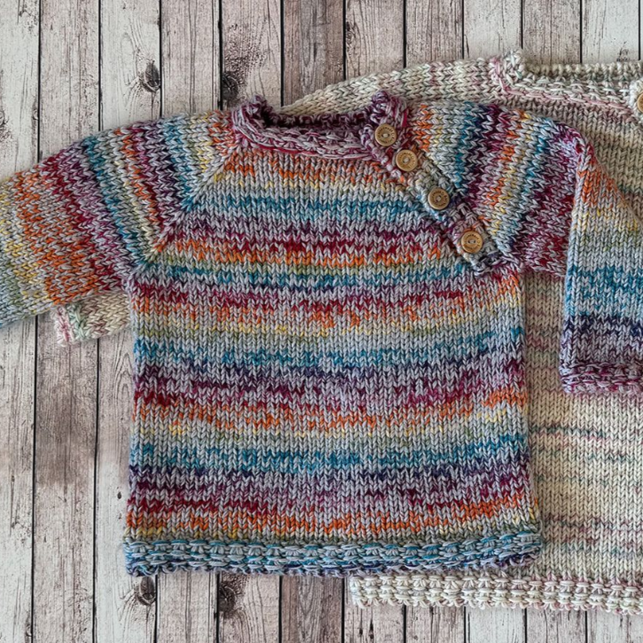 Bunter, gestrickter Babypullover mit Knopfverschluss.
