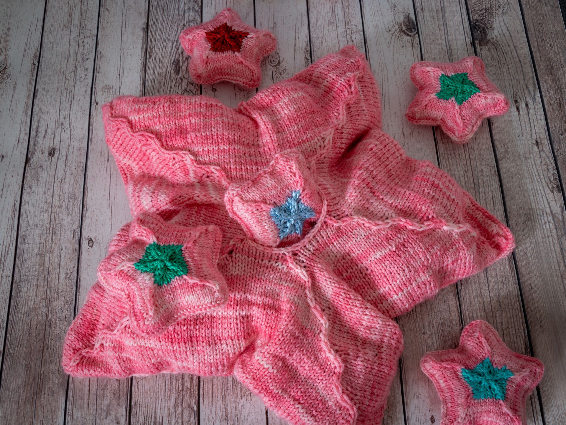 Nahaufnahme einer teilweise fertiggestellten blau-türkis gestrickten Socke, die die Ferse und die Strukturmuster zeigt.