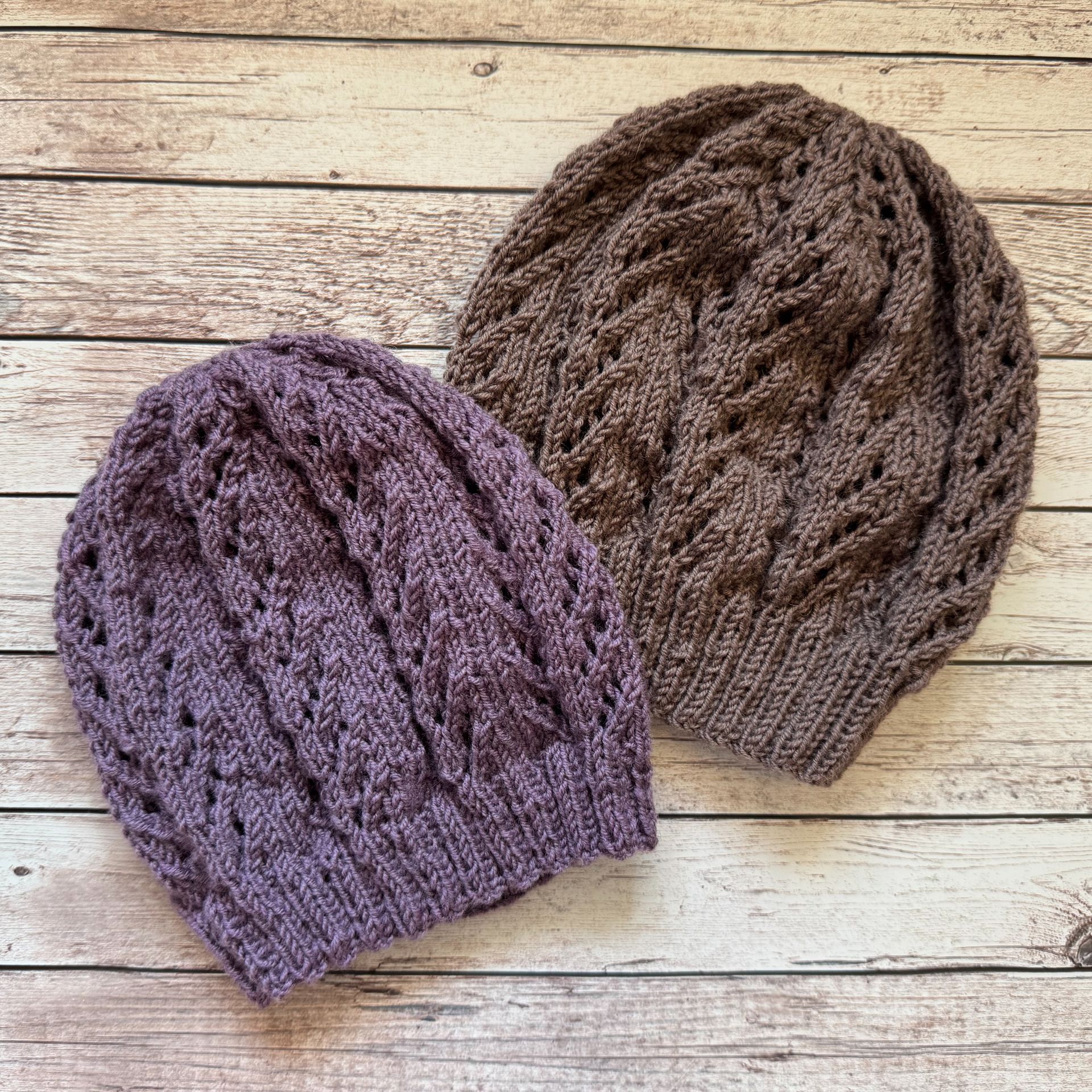 Zwei gestrickte Mützen: eine lila, eine braun. Beide haben ein strukturiertes, Lochmuster.