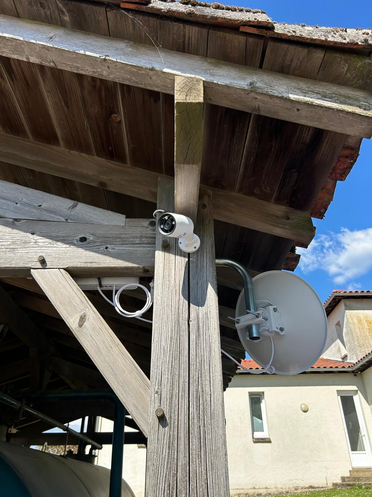 Les mains d'un électricien travaillant sur un tableau électrique, tenant une sonde rouge et touchant des fils.