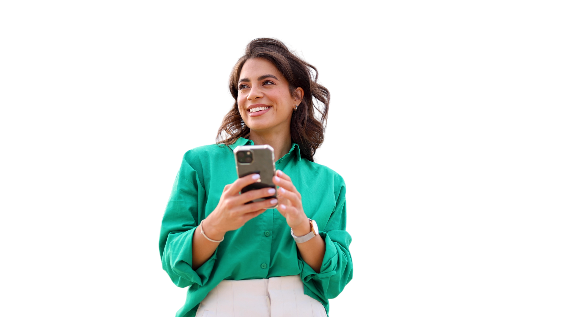 Femme en chemise verte tenant un téléphone, souriante et regardant vers le haut sur un fond blanc.