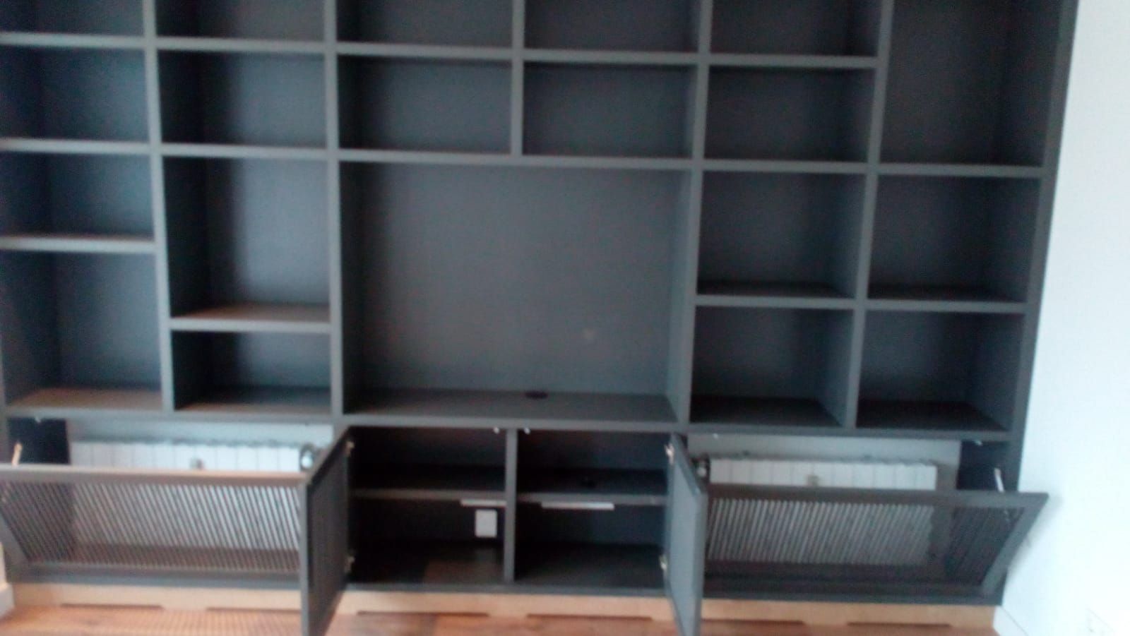 Una estantería con las puertas abiertas en una sala de estar.