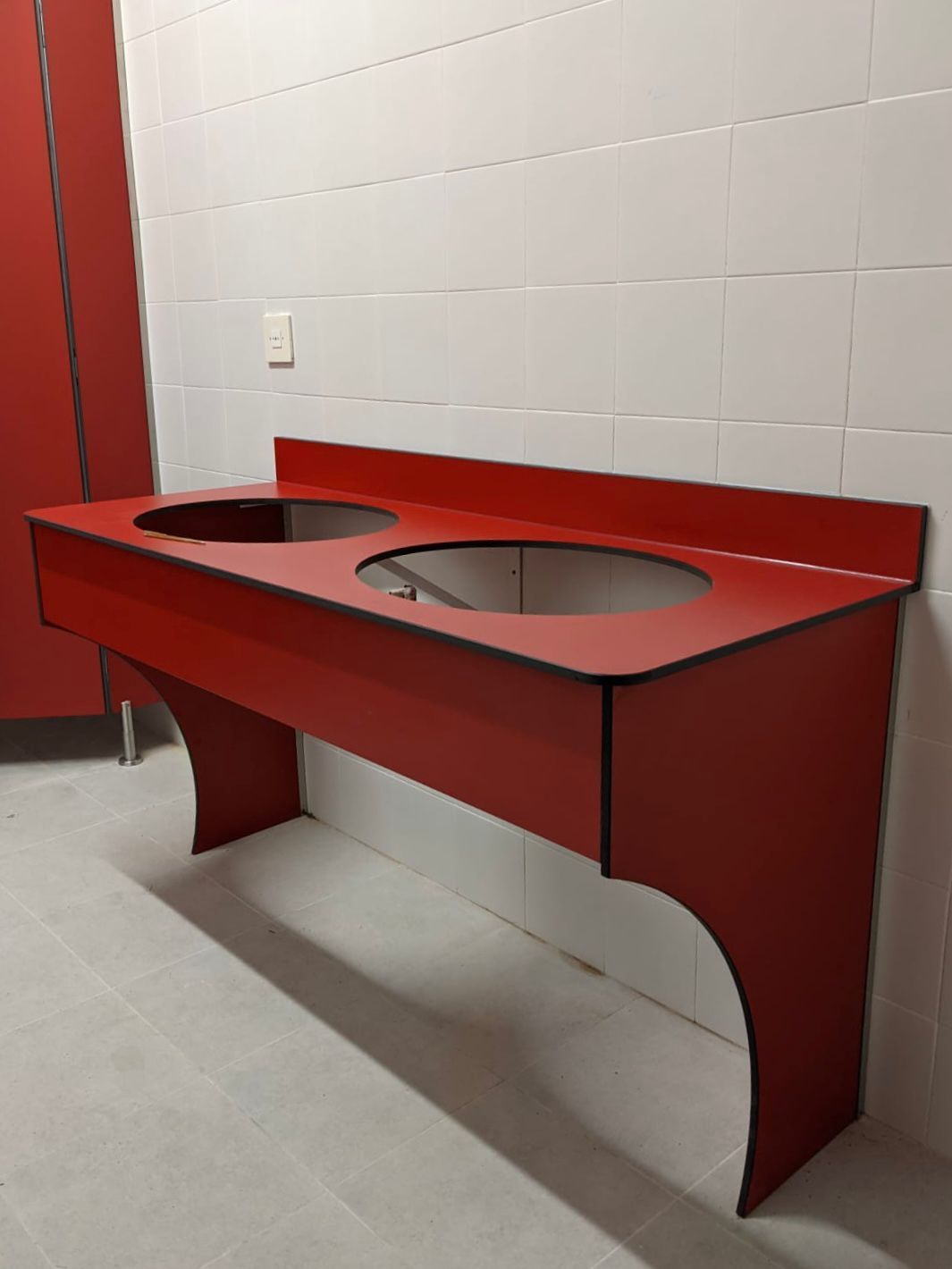 Un lavabo de baño rojo con dos agujeros.