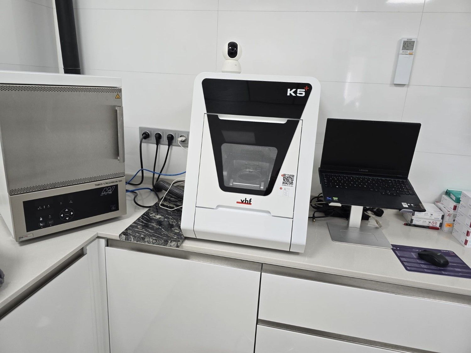 Una fresadora dental con la etiqueta K5 descansa sobre una encimera blanca