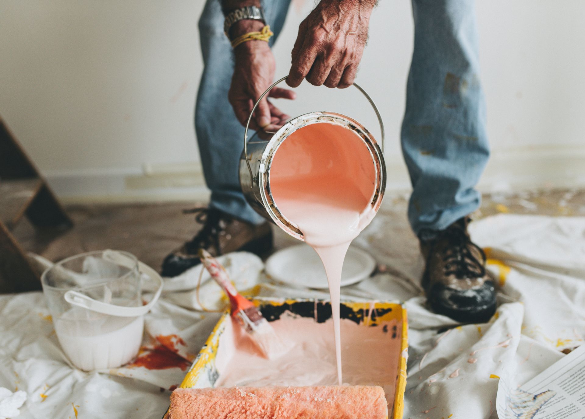 Un peintre qui verse de la peinture dans un bac